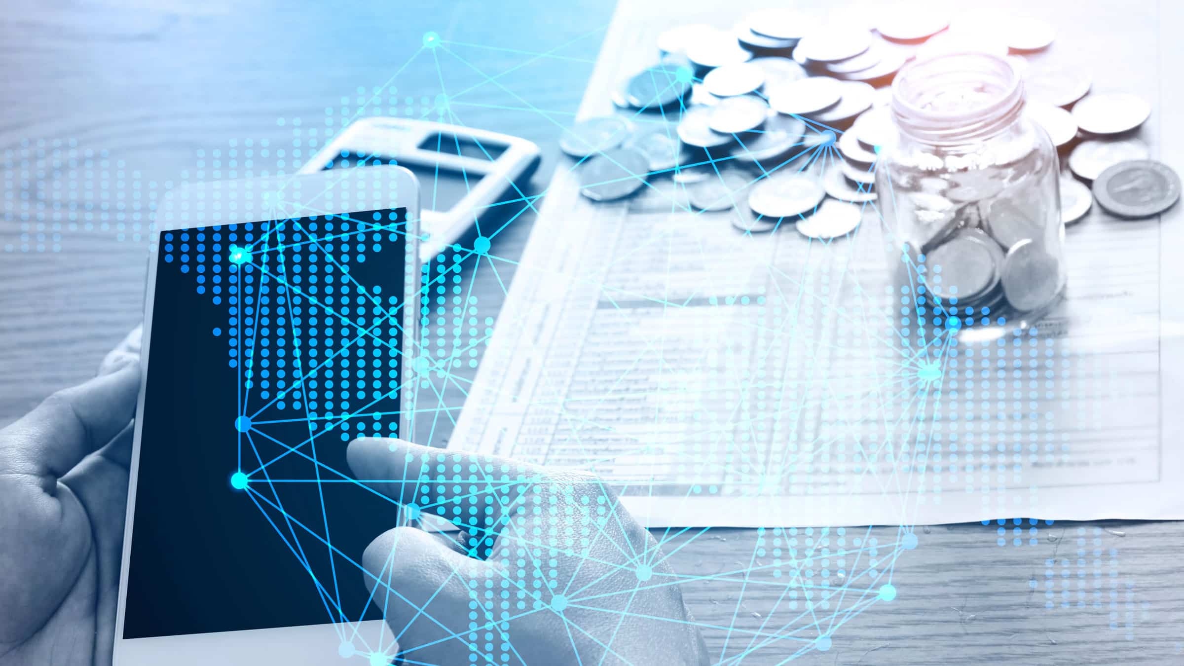 Photo of a person using a phone with a jar of coins in the background