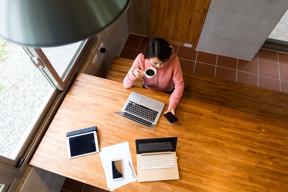 Top view of woman drinking coffee while checking phone
