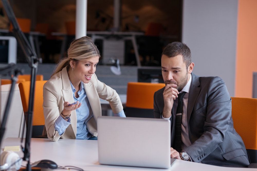 Young business peoplehaving a meeting while using a laptop